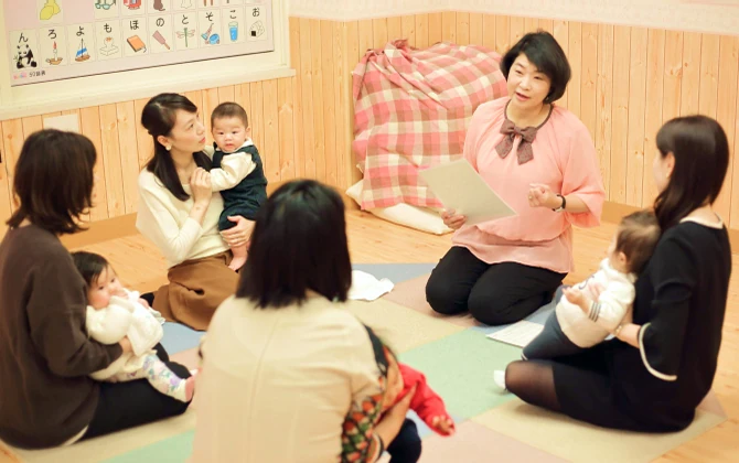 ベビーパークの教室で先生が親子の輪に向けてレッスンを行う様子